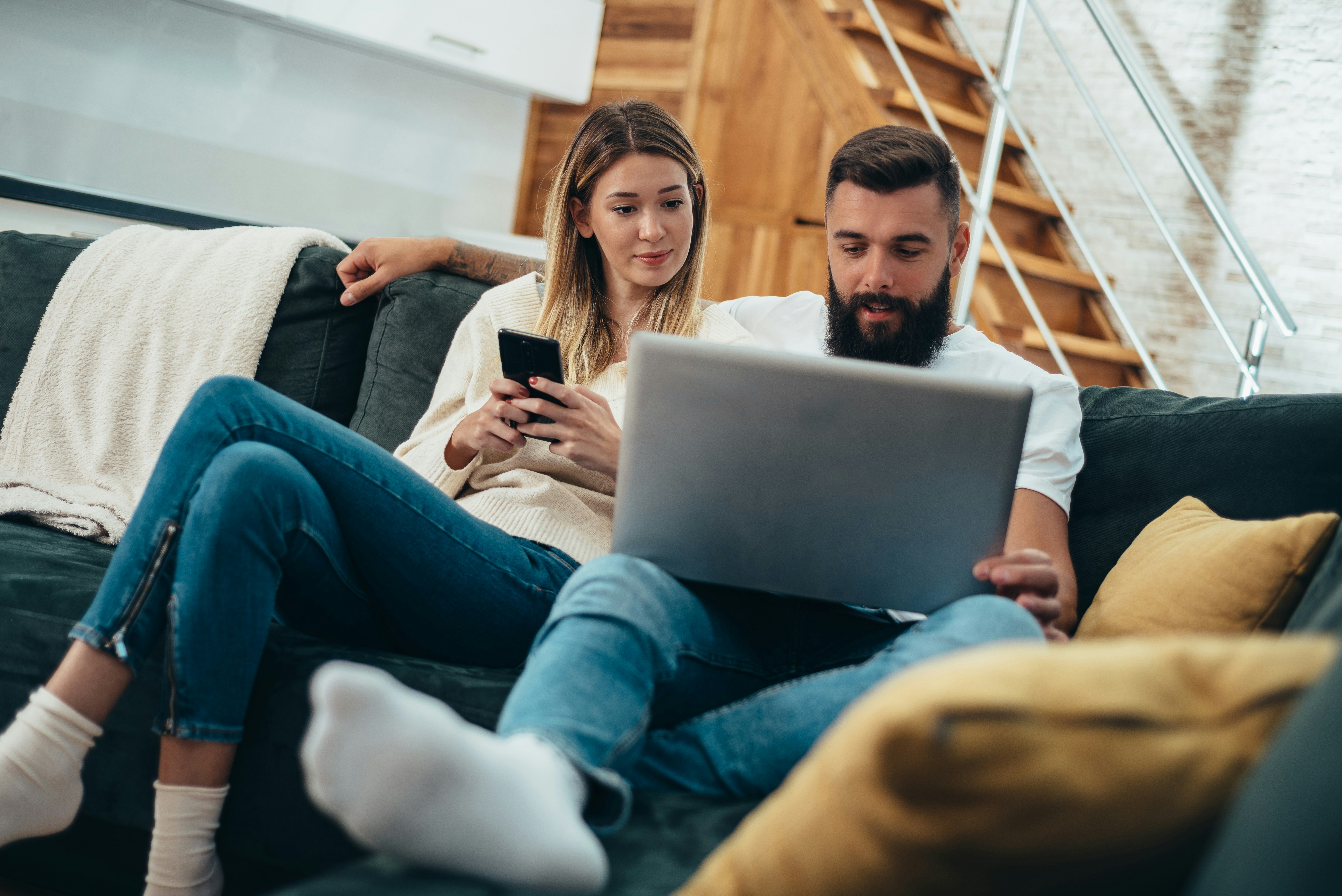 Couple at home completing the VitaStack intake on a laptop and phone