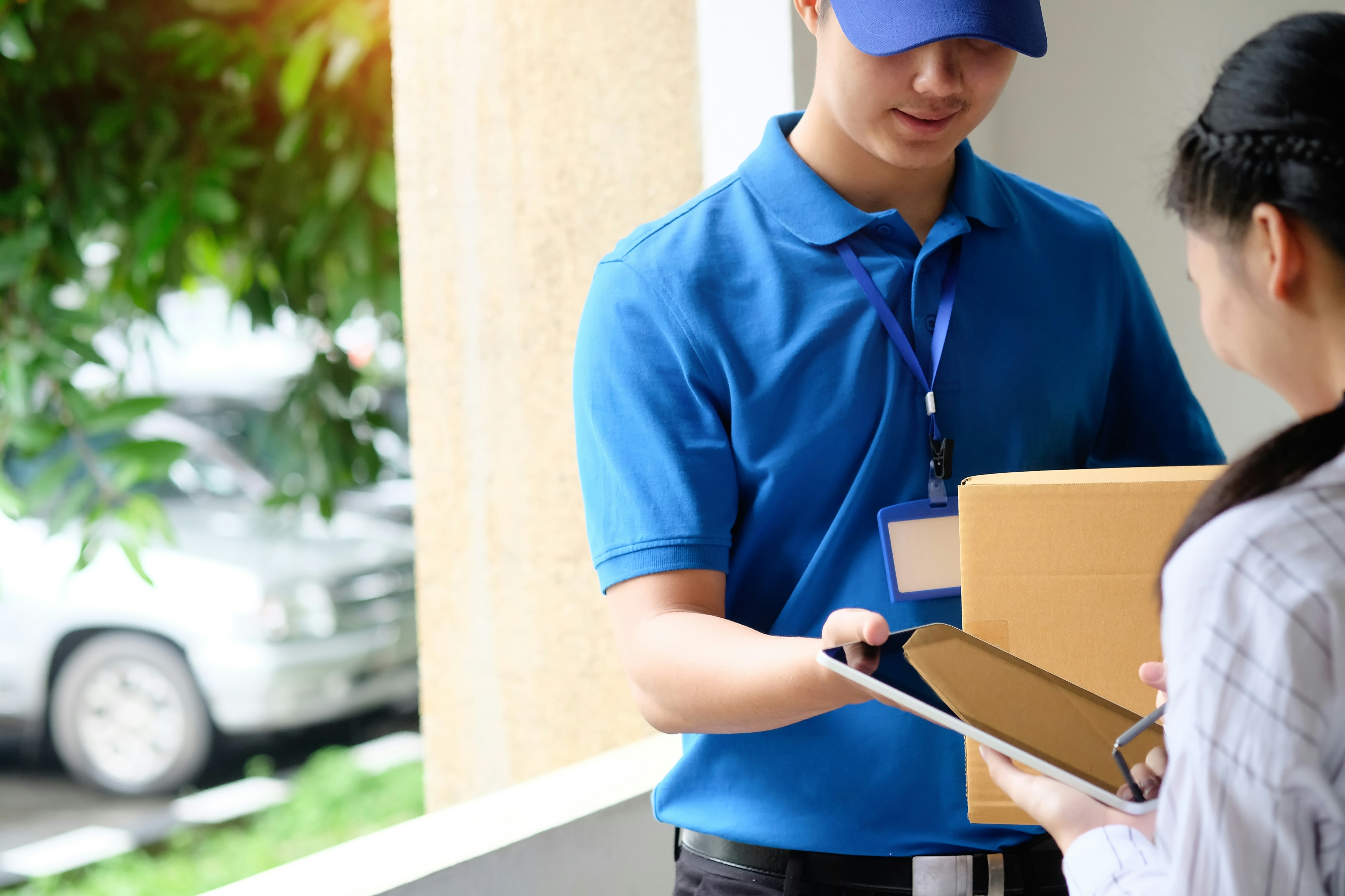 Delivery courier handing VitaStack medication package to a patient at the door